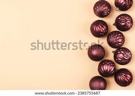 Christmas purple glitter bauble balls on neutral background with copy space. Top view, flat lay.