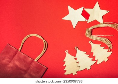 Christmas red background. Christmas wooden toys, twine and craft gift bag. Place for text. DIY gifts. - Powered by Shutterstock