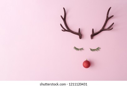 Christmas reindeer concept made of evergreen fir, red bauble decoration and antlers on pastel pink background. Minimal winter holidays idea. Flat lay top view composition. - Powered by Shutterstock