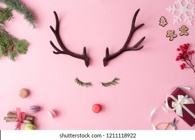 Christmas reindeer concept with presents, decoration, and winter things on pastel pink background. Minimal winter holidays idea. Flat lay top view composition.