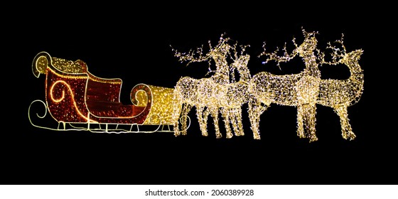 Christmas reindeer from light bulbs with red sleigh of Santa Claus on a black isolated background. Christmas, New Year. Copy space - Powered by Shutterstock
