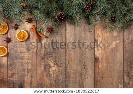 christmas rustic background. Christmas winter holidays greeting template. Christmas tree branches, oranges, cinnamon, anise and cones on dark wooden background with copy space. Flat lay