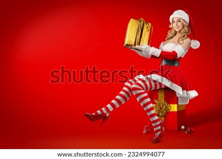 Christmas Santa Helper Elf female character holding gift boxes, new year surprise. Pin up Women wearing Fancy red Dress and hat. Ladies Xmas Party Outfit. Girl dressed as Santa Claus.
