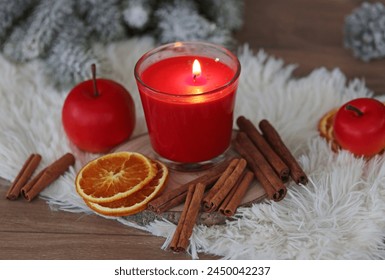 Christmas scented candle: aromatic candle with traditional winter spices, slices of oranges, apples and cinnamon sticks. - Powered by Shutterstock