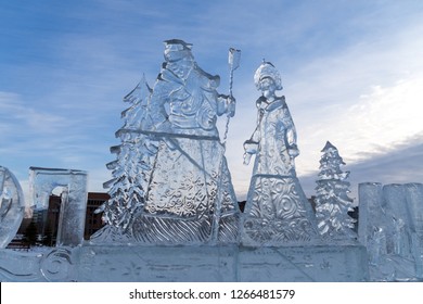 Christmas Sculpture Of Father Frost And The Snow Maiden, Carved Out Of Ice, Stands Outside Against The Sky.