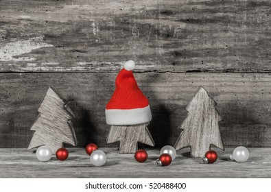 Christmas season, decorated wooden forest trees ornate with red Santa cap and red and white Christmas balls