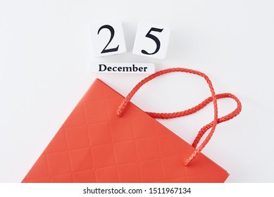 Christmas Shopping Concept, Presents For Family Or Friends. Red Shopping Bag And Calendar With Date 25 December On White Background, Top View