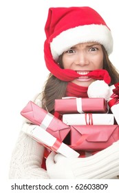 Christmas Shopping Woman Stress. Young Shopper Holding Christmas Gifts / Presents Stressed, Frustrated And Angry. Funny Woman Biting Her Santa Hat And Arms Full Of Gifts. Isolated On White Background.