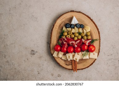 Christmas Snack Tree On Rustic Wooden Board Over Beige Stone Background. Cheese Plate. Christmas Food Concept. Top View With Copy Space