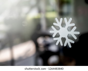 Christmas Snowflake Sticker Decoration On Window Glass In Cafe On Green Garden Background With Copy Space.