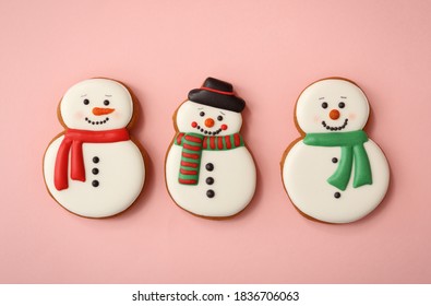 Christmas snowman shaped gingerbread cookies on pink background, flat lay - Powered by Shutterstock