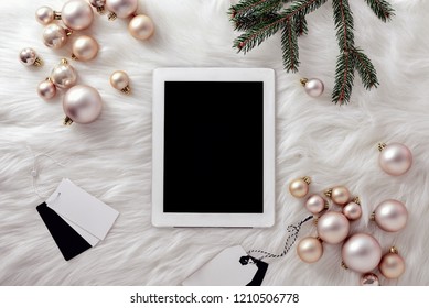 Christmas social media concept, fashion blogging or shopping online during Christmas holidays, white tablet lying down on a faux fur, view from above, space for a text