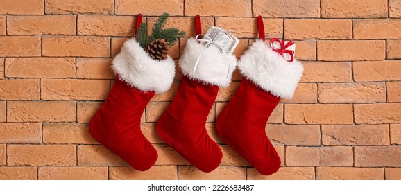 Christmas socks with gifts hanging on brick wall - Powered by Shutterstock