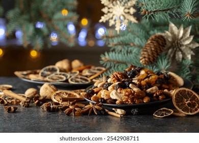 Christmas spices, various nuts, raisins, and dry citrus slices on a kitchen table. Christmas still-life with spruce branches and dried fruits. - Powered by Shutterstock