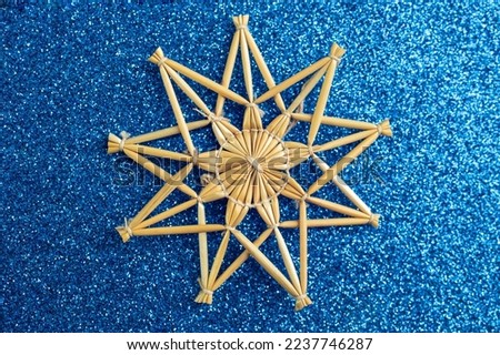 Christmas star decoration made with golden straws and thread on blue glitter background, soft focus close up Stock photo © 