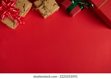 Christmas still life with gifts in the top of a red background. Copy ad space. Mockup, layout for promotional text. Boxing Day. Xmas and New Year's preparations. Packing presents. Web banner. Flat lay