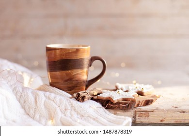 Christmas still life. Mug of hot steamy tea, gingerbread cookies at wooden background with glares. Cozy morning breakfast with homemade sweets and cup of coffee. Winter food, drinks, new year lights. - Powered by Shutterstock