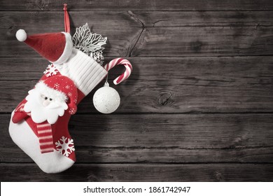 Christmas Stocking With Gifts Hanging On Dark Old Wooden Background