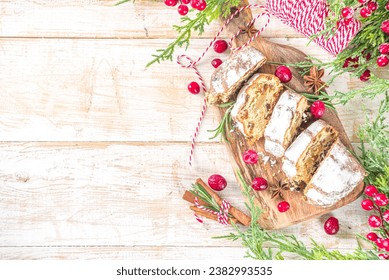  Christmas stollen with icing sugar, marzipan and raisins. Traditional Dresden christ pastry. On table background with fir tree branches and Christmas decoratioon top view copy space - Powered by Shutterstock