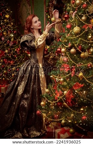 Christmas stories. Beautiful kind princess girl with curly red hair decorates the Christmas trees for Christmas in her castle. 