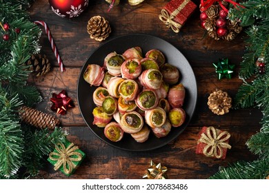 Christmas Streaky Bacon Wrapped Brussel Sprouts With Decoration, Gifts, Green Tree Branch On Wooden Rustic Table