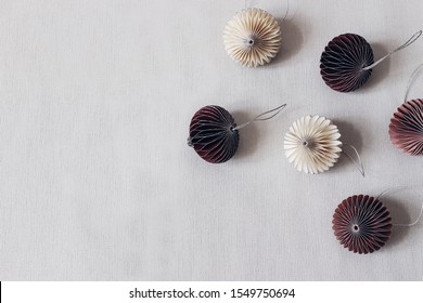 Christmas styled stock composition. Decorative white and crimson paper Christmas ornaments on grey table linen background. Flat lay, top view. Winter festive pattern, empty copy space. - Shutterstock ID 1549750694