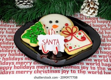 Christmas Sugar Cookies With Candy Cane Place Card Holder For Santa Claus On Black Plate