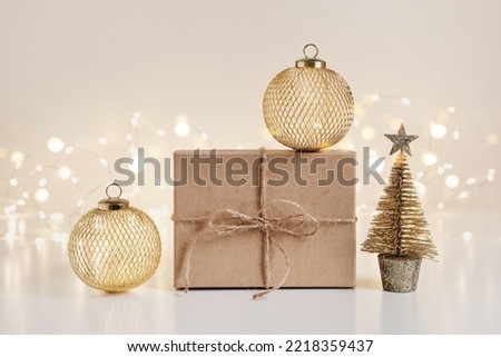 Christmas sustainable gift boxes composition with golden balls and Christmas tree on shining bokeh background.