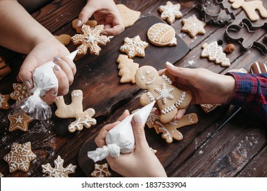 Christmas sweets. Friends decorating freshly baked gingerbread cookies. Festive food, family culinary, celebrating traditions concept