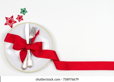 Christmas Table Place Setting With Plate, Cutlery, Pine Branches,  Ribbon And Red Berries. Winter Holidays And Festive Background. Christmas Eve Dinner, New Year Food Lunch. View From Above, Top