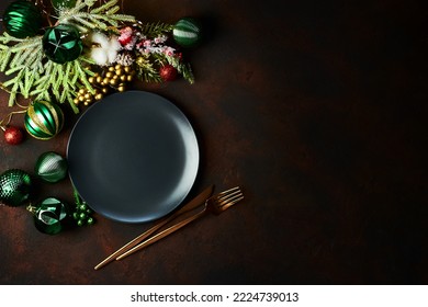Christmas table setting with black empty plate and xmas decor.