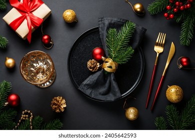 Christmas table setting with black plate, wine glass, cutlery and holidays decorations. - Powered by Shutterstock