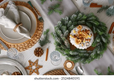 Christmas table setting with cake, wreath, pine cones and burning candles - Powered by Shutterstock