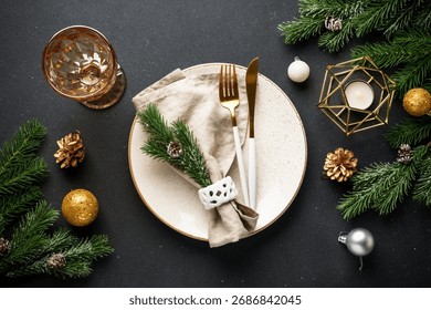 Christmas table setting. Christmas dinner - black plates with cutlery and decorations on black background.