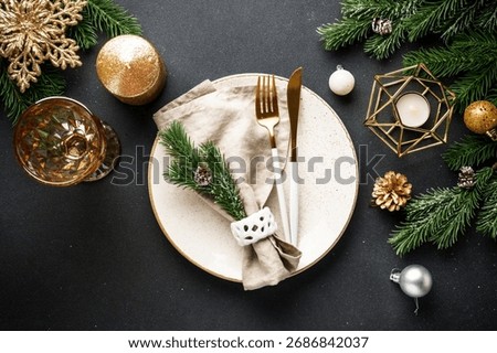 Christmas table setting. Christmas dinner - black plates with cutlery and decorations on black background.