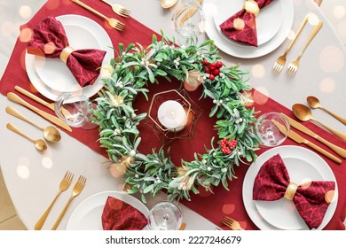 Christmas table setting with mistletoe wreath in dining room, top view - Powered by Shutterstock