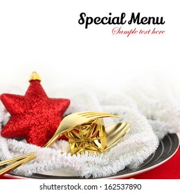 Christmas table setting with ornaments on a plate