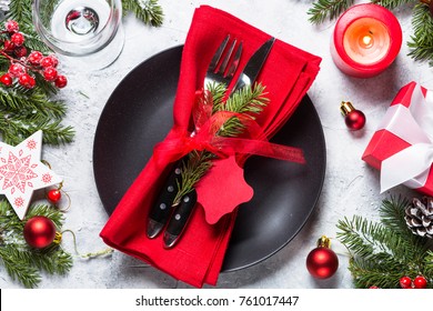 Christmas Table Setting - Plate, Cutlery, Wineglass, Candle With Christmas Decorations Over Gray Stone Table. Top View.