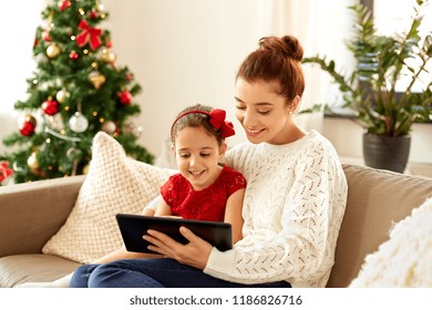 Christmas, Technology And Family Concept - Happy Mother And Little Daughter With Tablet Pc Computer At Home