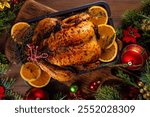 Christmas and Thanksgiving traditional baked chicken. Whole roasted chicken for holiday dinner, with oranges and thyme, on Christmas or Thanksgiving decorated table