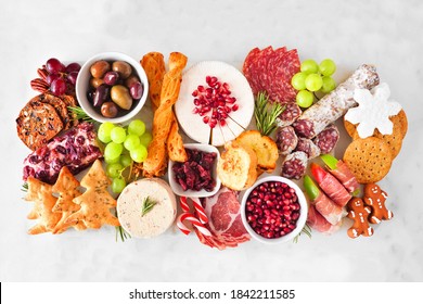 Christmas Theme Charcuterie Board. Top View Against A White Marble Background. Variety Of Cheese And Meat Appetizers.