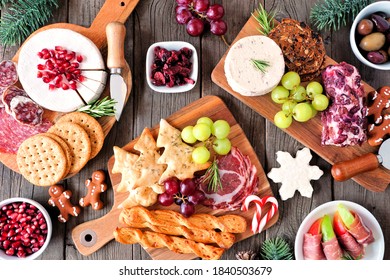 Christmas Theme Charcuterie Table Scene Against A Dark Wood Background. Assortment Of Cheese And Meat Appetizers. Top View.