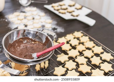 Christmas time, cookies are baked at home in a star shape. Shortcrust pastry stars are covered with chocolate and sprinkled with powdered sugar. - Powered by Shutterstock