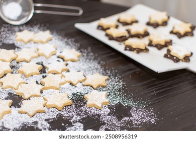 Christmas time, cookies are baked at home in a star shape. Shortcrust pastry stars are covered with chocolate and sprinkled with powdered sugar.  - Powered by Shutterstock