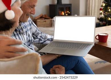 Christmas time, Senior couple enjoying holiday video call at home with laptop and coffee, copy space. Elderly, technology, virtual communication, lifestyle, cozy, leisure - Powered by Shutterstock