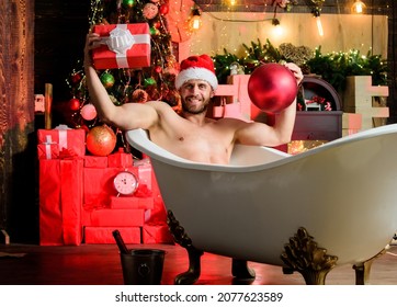 Christmas Tour Concept. Enjoy New Years Eve Celebrations Book Stay Hotel Apartment. Man Lying In Bathtub With Gift Box. Sexy Hedonist Relax In Bathtub. Stunning Winter Views Enjoyed From Bathtub