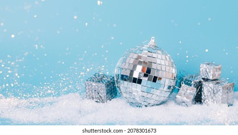 Christmas toy disco ball slugs on pastel blue background, snow sparkles, confetti. Christmas or New Year mockup concept - Powered by Shutterstock