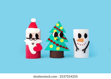 Christmas toy from toilet tube roll, paper toy santa claus, snowman, reindeer, tree on blue background. Holiday easy DIY for kids, decoration idea for winter season home xmas party. Children's crafts. - Powered by Shutterstock