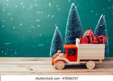 Christmas toy truck with gift boxes and pine tree on wooden table over green background - Powered by Shutterstock