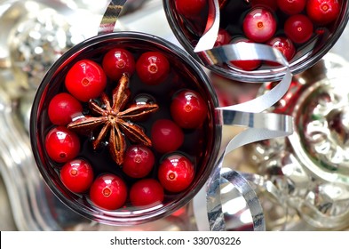 Christmas Traditional Warm Alcohol Drink Or Cocktail With Spices And Cranberries Surrounded With Sparkling Decorations